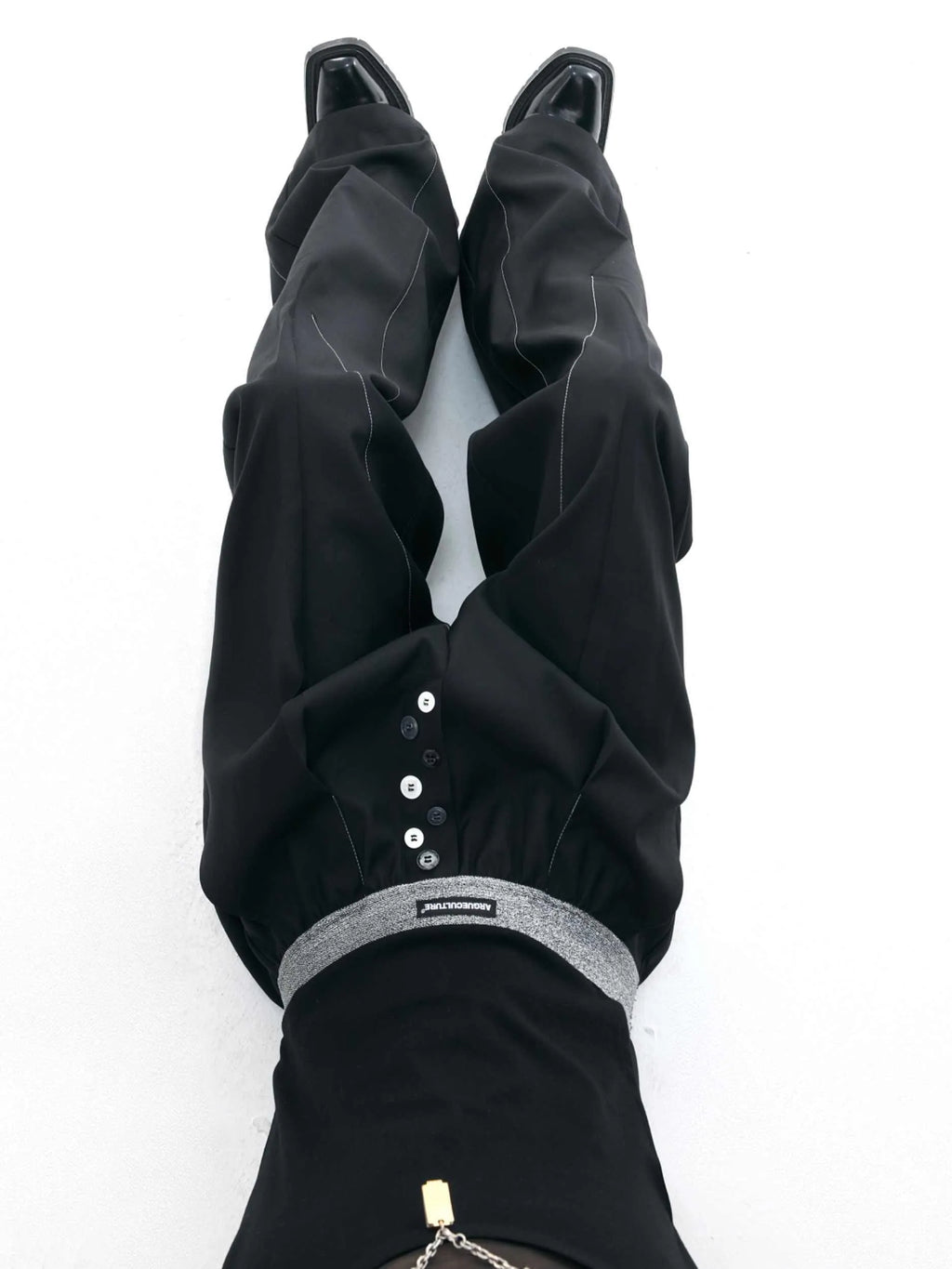 A pair of high-waisted straight-leg casual trousers in a black polyester-cotton blend with a button fly and open hem.