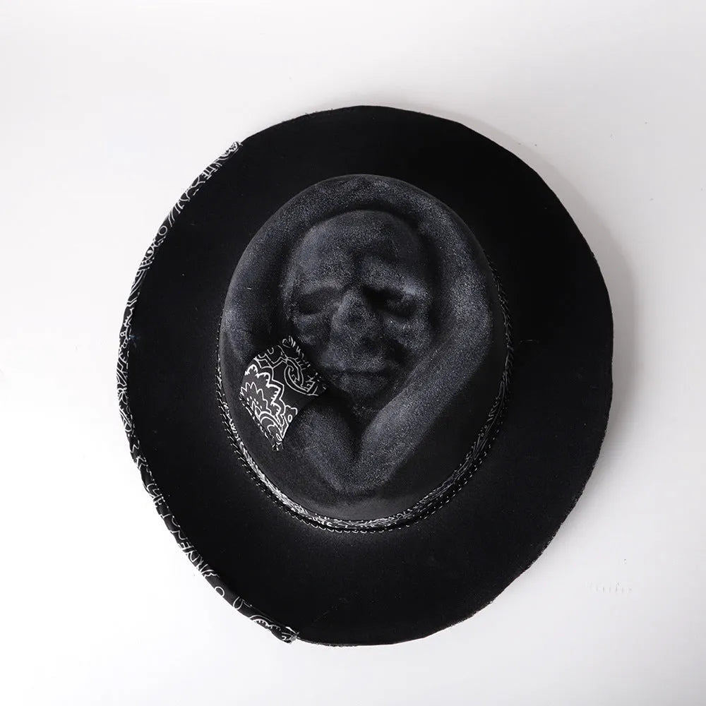 Handmade wool felt skull hat with a pointed conical crown on a neutral background.