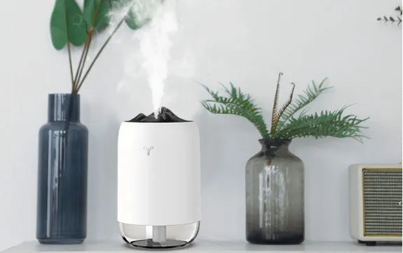 Mini cylindrical USB humidifier in turquoise green with night light on wooden desk