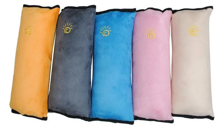 Children car pillow in grey micro-suede fabric attached to a car seat belt shoulder strap