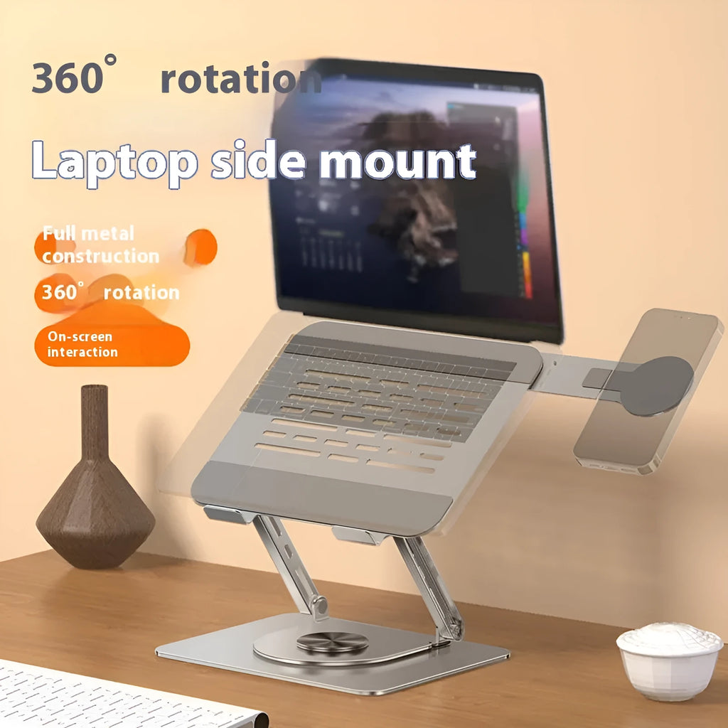 Silver carbon steel laptop stand with rotatable base and a side-mounted magnetic phone holder on a desk.