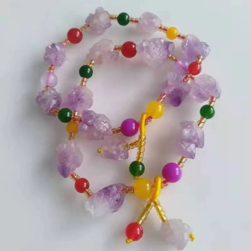 Women's amethyst bead bracelet with a Chinese fu character charm on a white background.
