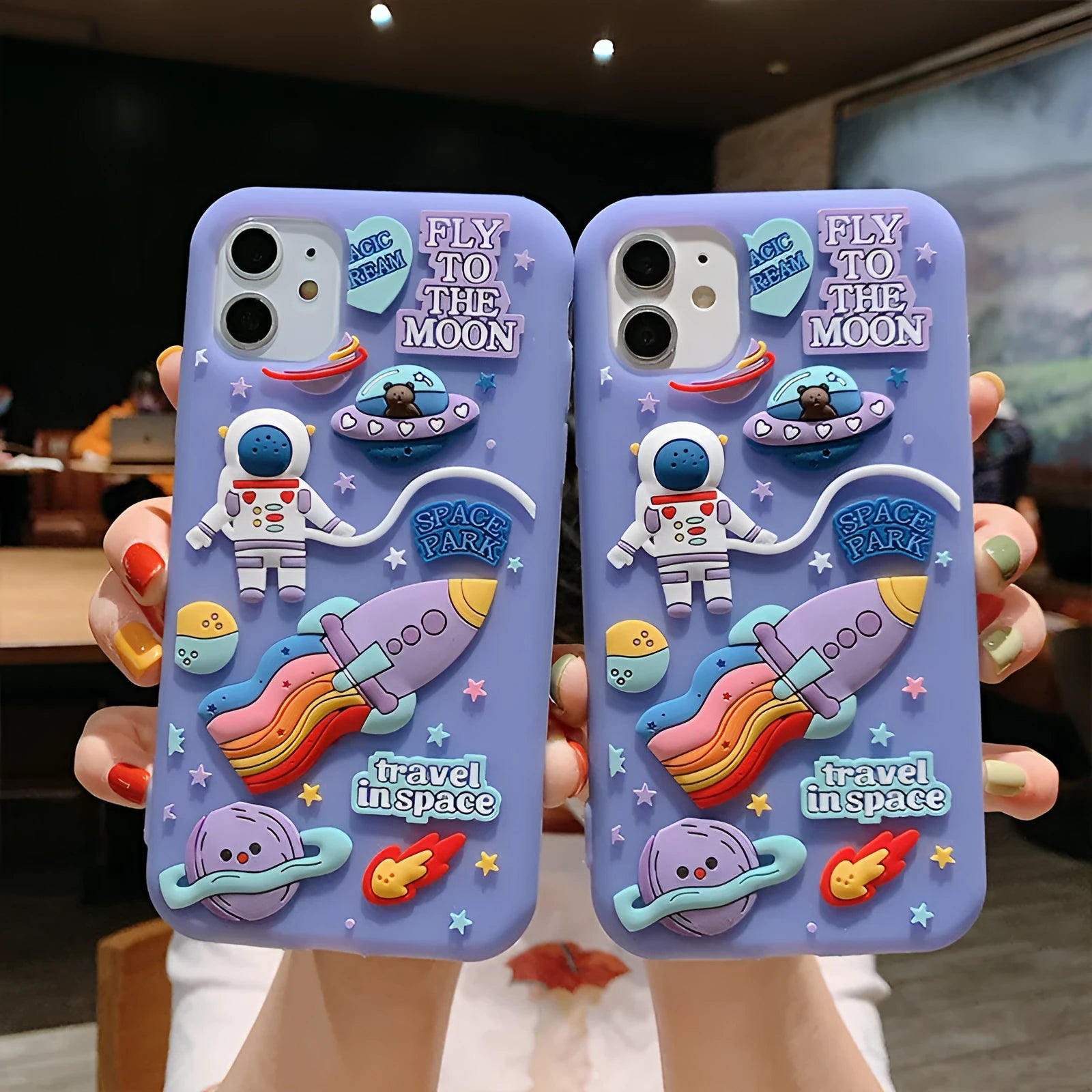 Purple silicone iPhone case with a cartoon astronaut graphic, showing front and back views.