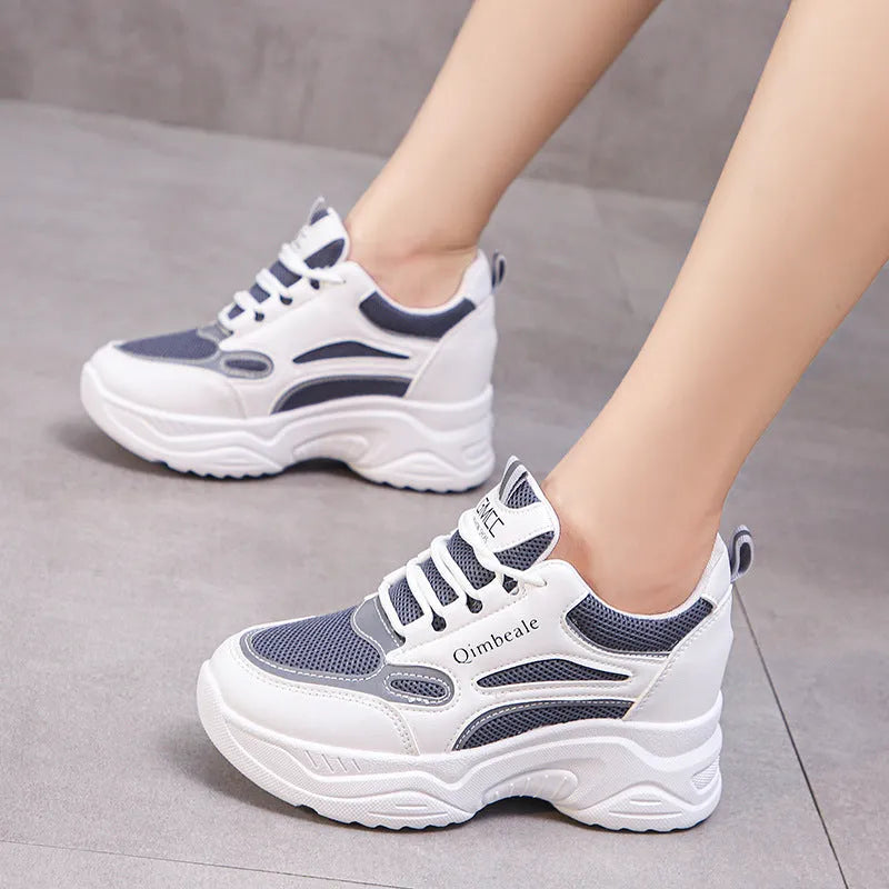 White height increasing dad shoes with mesh upper and wedge heel on a neutral background