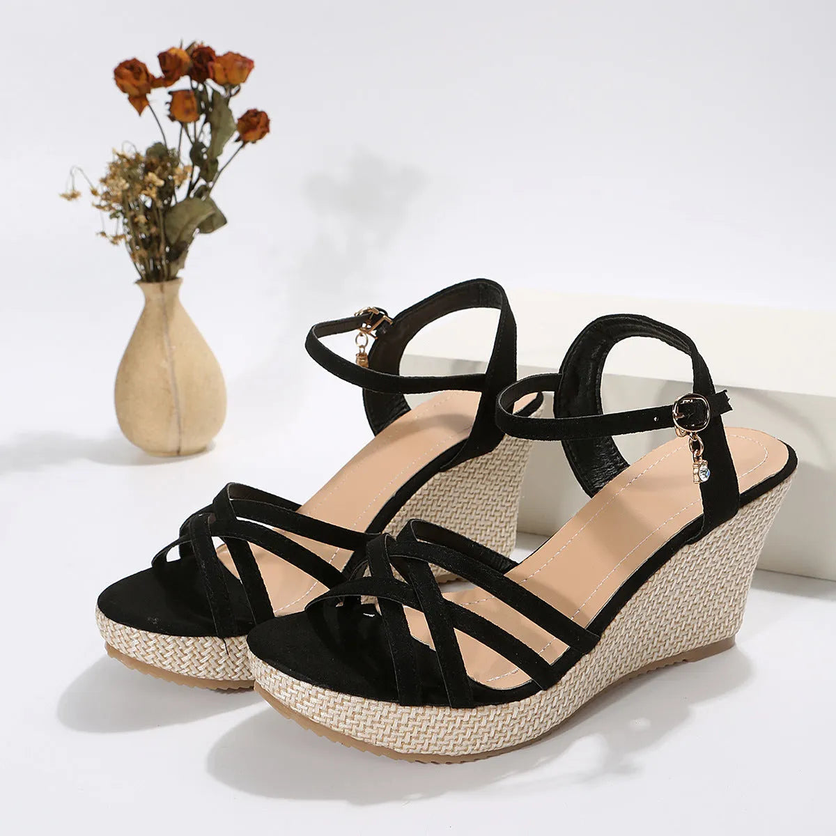 Women's black wedge sandals with cloth upper and fish-mouth toe design on a simple background.