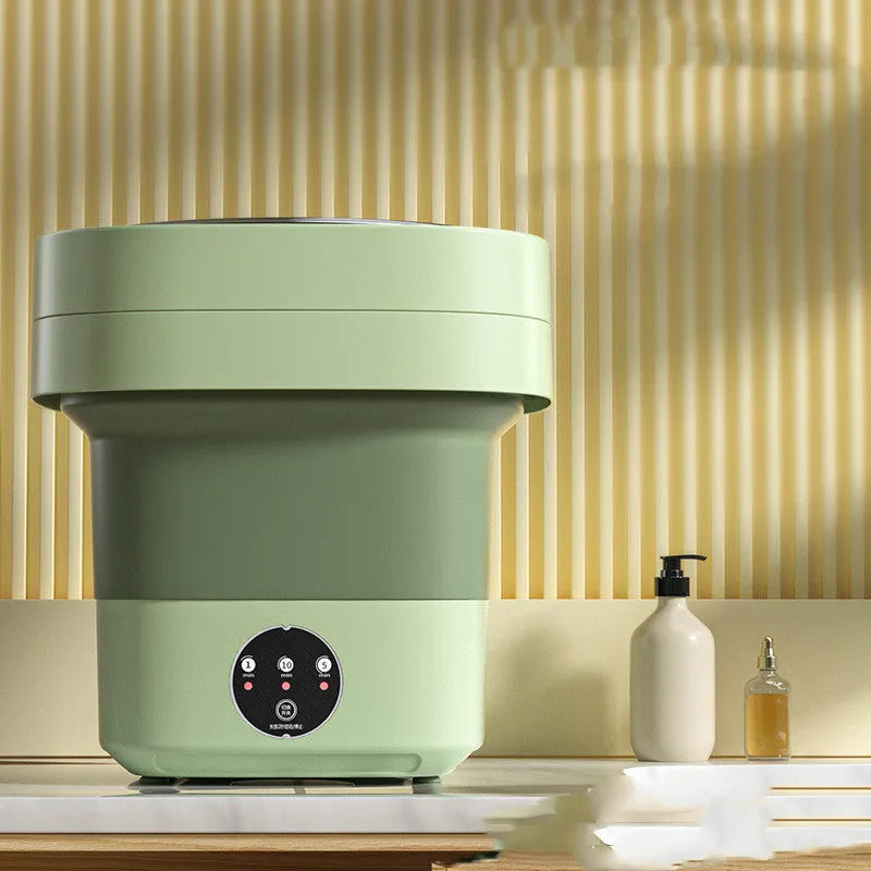 Green foldable portable mini washing machine for socks and underwear with drain pipe and basket.