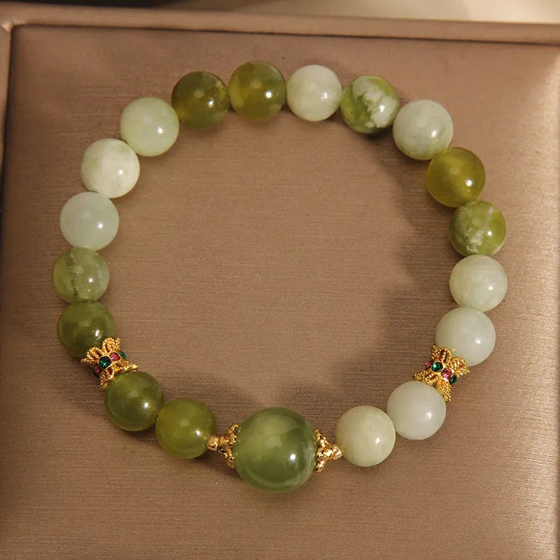 Xiuyan jade green women's bracelet with sweet Mori style design on a wrist.