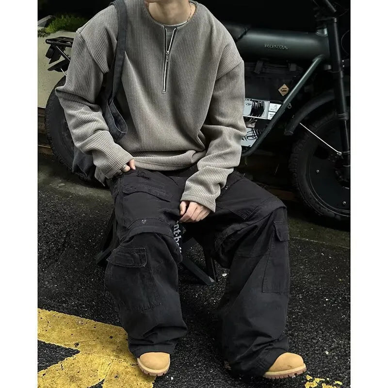 A grey women's loose-fitting long sleeve pullover top with a small letter pattern, shown on a hanger.
