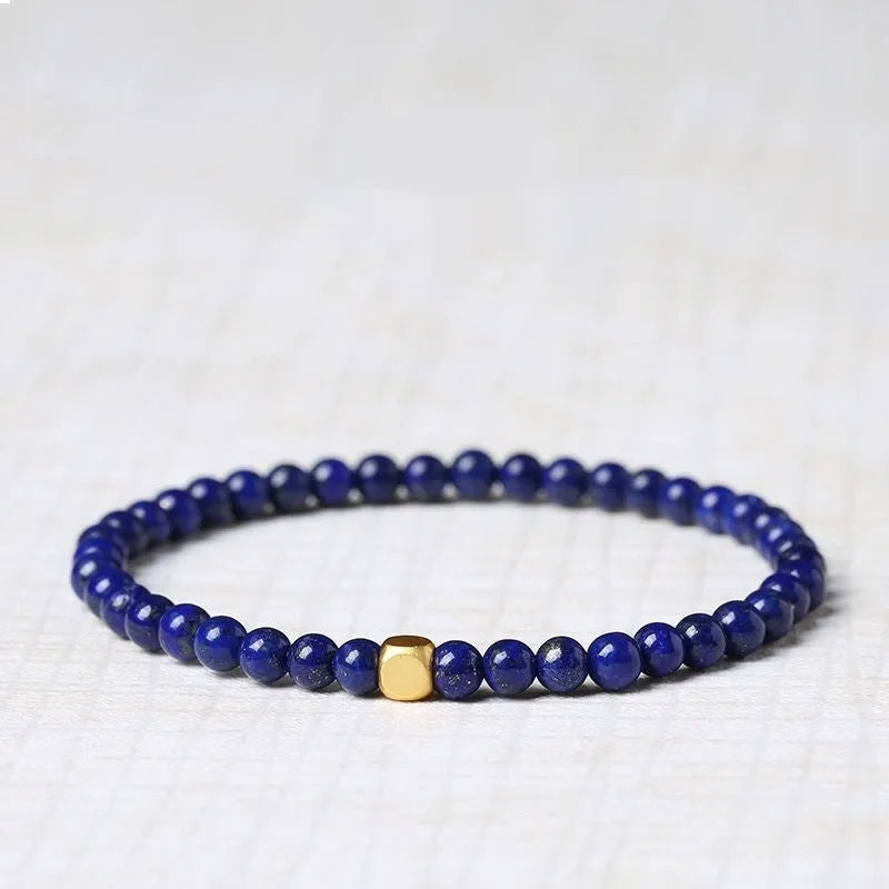 Close-up of a women's bracelet with a large 16mm geometric green gold stone crystal bead.