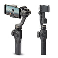 Black handheld mobile phone gimbal stabilizer on a table, made from ABS plastic.