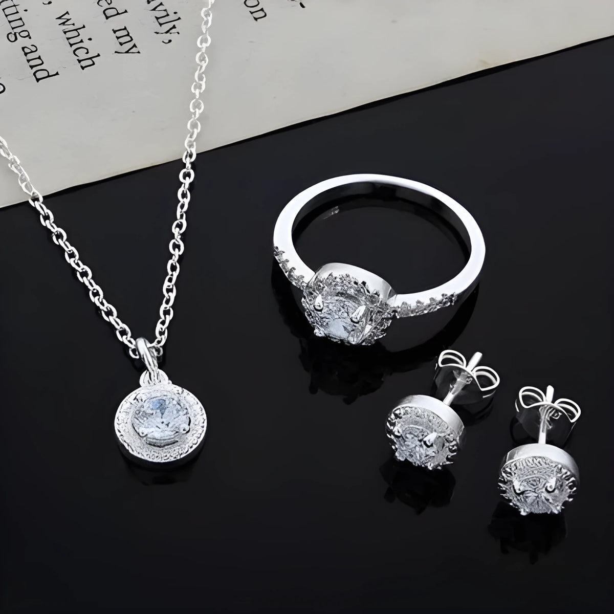 Zircon jewellery suit with inlaid apple ring and necklace silver tone on white background