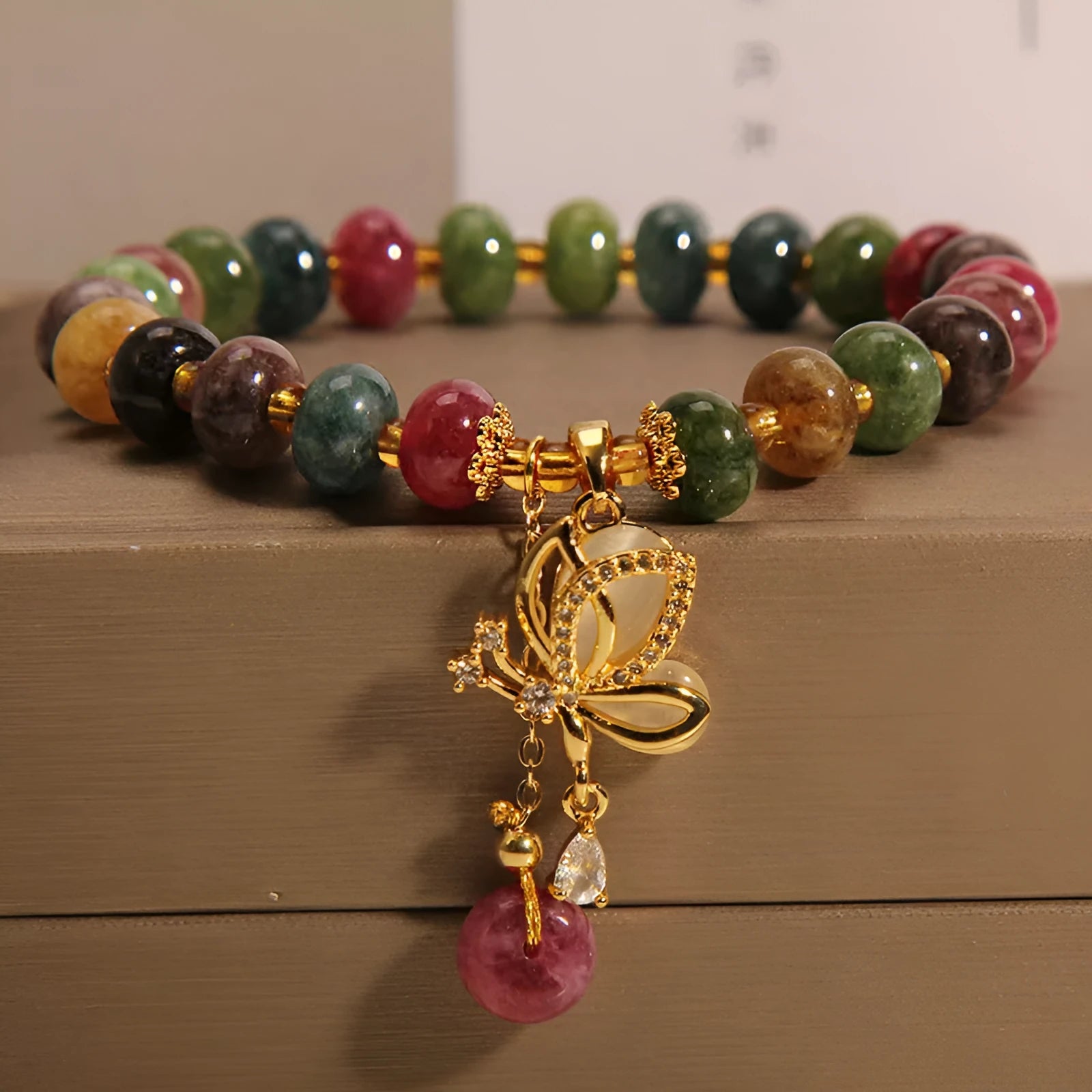 Colourful women's bracelet with butterfly charm and bead accents on alloy band