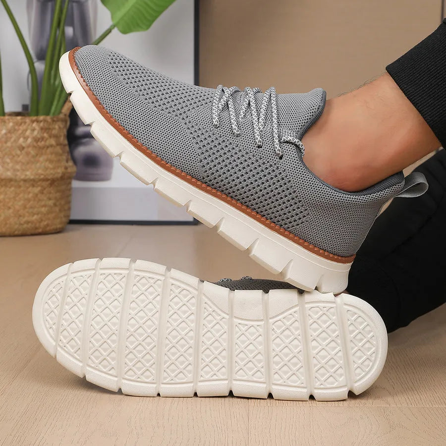 Men's grey and black low-heel casual sneakers with woven mesh fabric uppers and round toe.