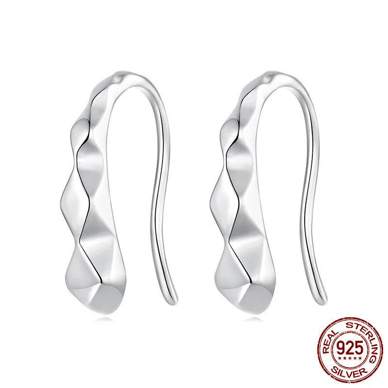 Close-up of S925 sterling silver rhombus earrings with diamond plaid pattern on a neutral background