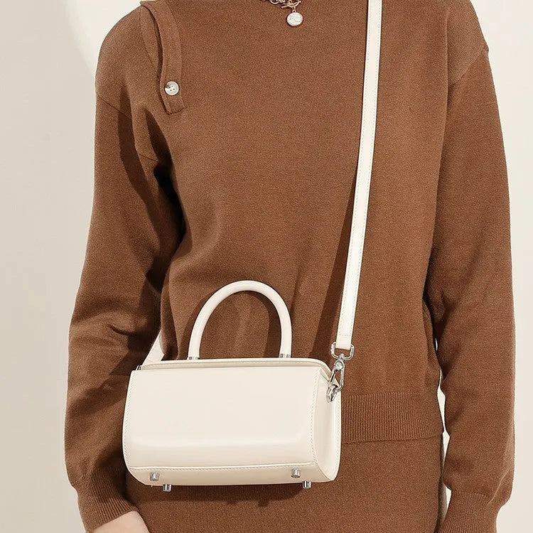Brown leather women's crossbody bag with a box shape and clamshell opening, shown with interior phone and file pockets.