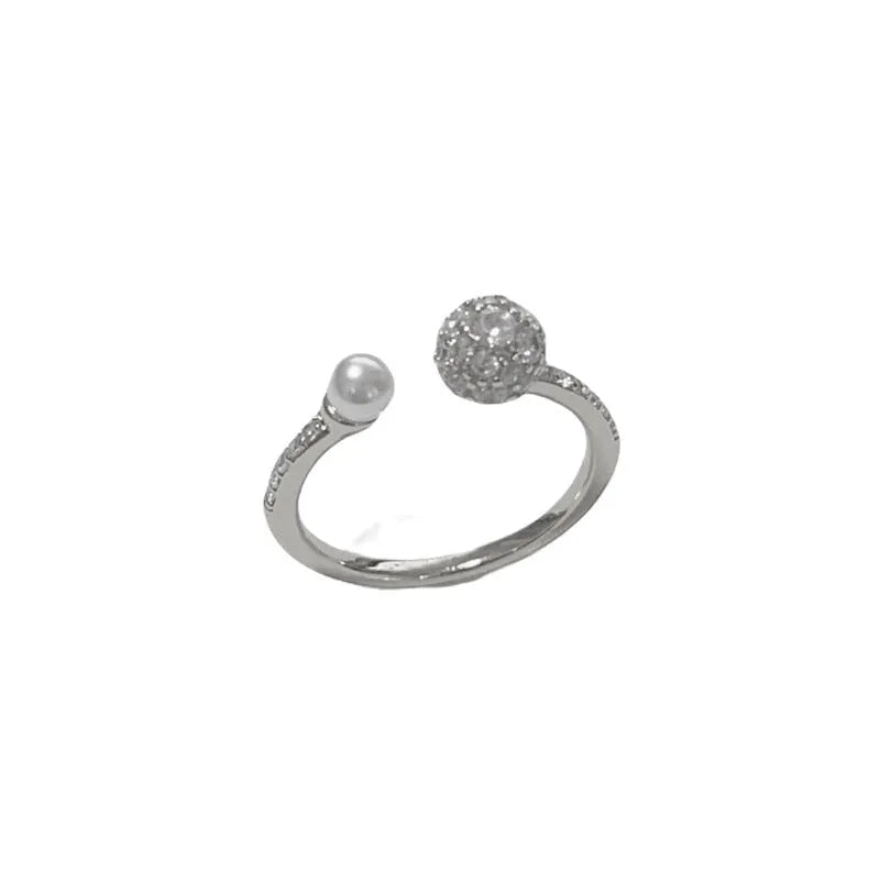 Gold and silver coloured open-end ring with round zircon on a geometric band.