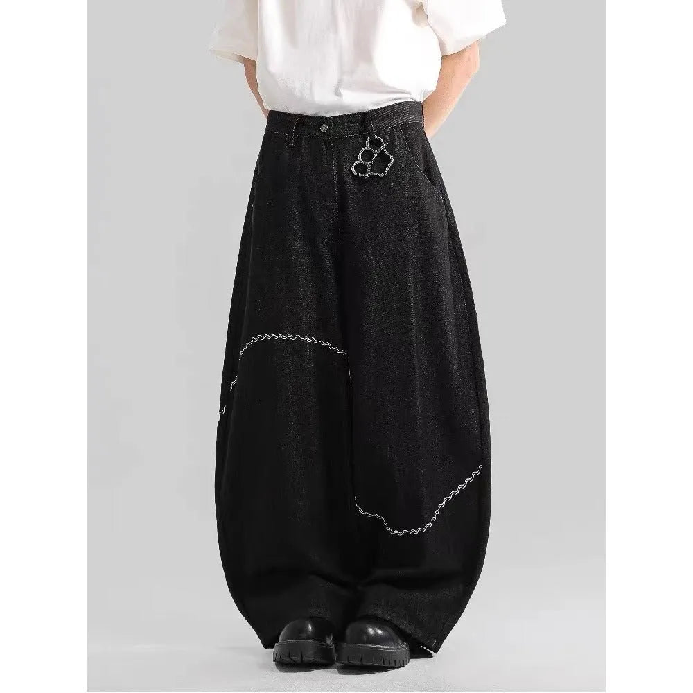 Black straight-leg denim trousers laid flat, showing zip fly and mid-waist design.