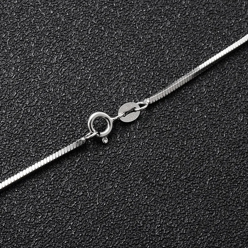 S925 sterling silver plated platinum necklace with fine snake bone chain in silver on neutral background