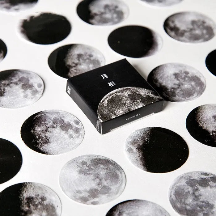 Box containing 45 black moon phase and planet calendar stickers on self-adhesive paper.