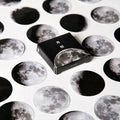 Box containing 45 black moon phase and planet calendar stickers on self-adhesive paper.