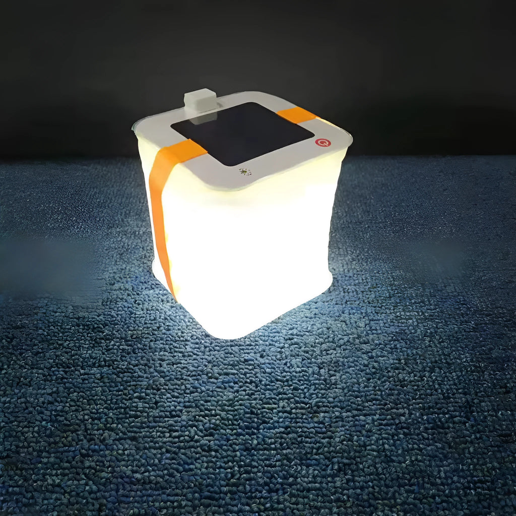 White solar inflatable waterproof camping LED lantern with handle, collapsed flat on a table