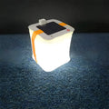 White solar inflatable waterproof camping LED lantern with handle, collapsed flat on a table