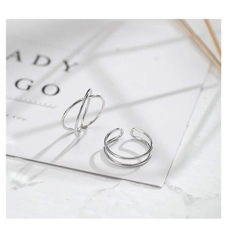 Silver geometric cross ring with adjustable opening on female hand