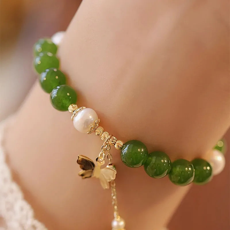 Natural green chalcedony bracelet with round geometric beads on a wrist.