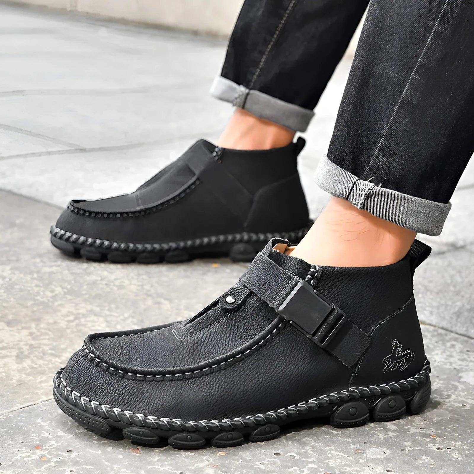 Casual black slip-on shoes with handmade stitching and a flat, low-heel sole.