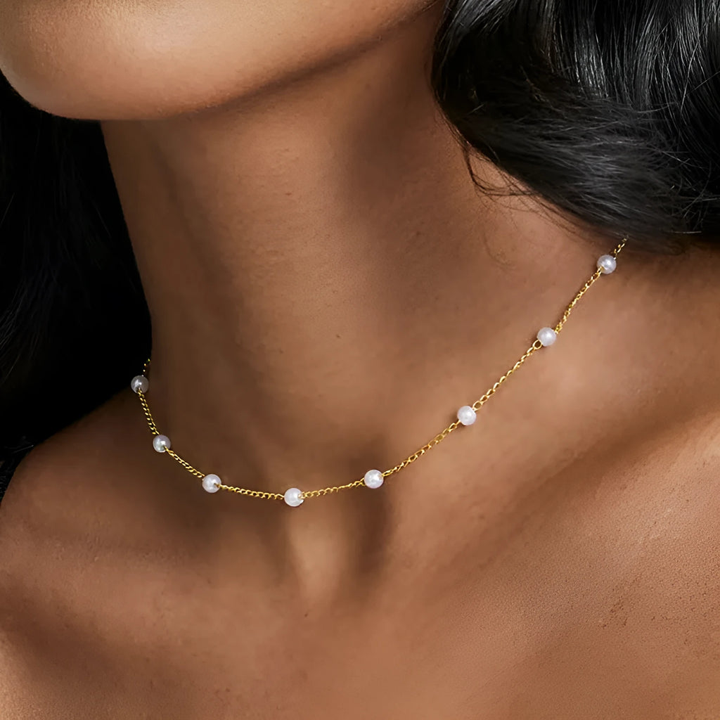 Pearl necklace with copper geometric pendant and ball bead chain on dark background