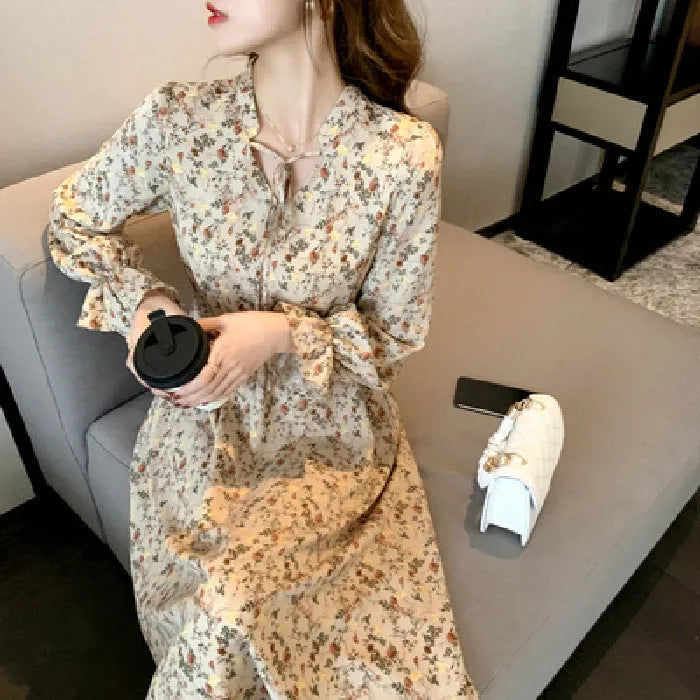 Retro waist-cinching floral A-line dress in apricot colour with princess-style seams, shown on a woman