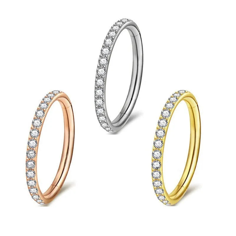 A round stainless steel seamless nose ring on a grey background, shown in a gold plated finish.