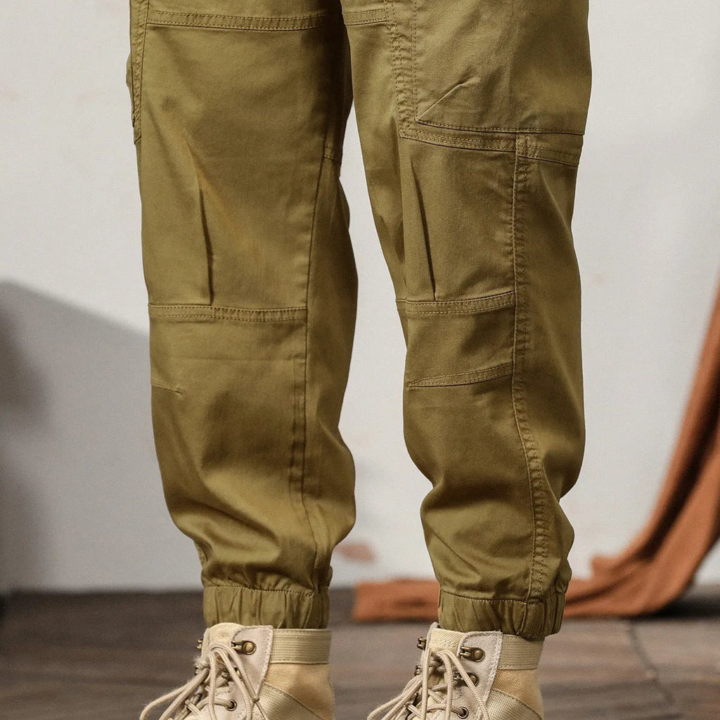 Men's khaki cotton harem pants with tapered leg and ankle band on a mannequin.