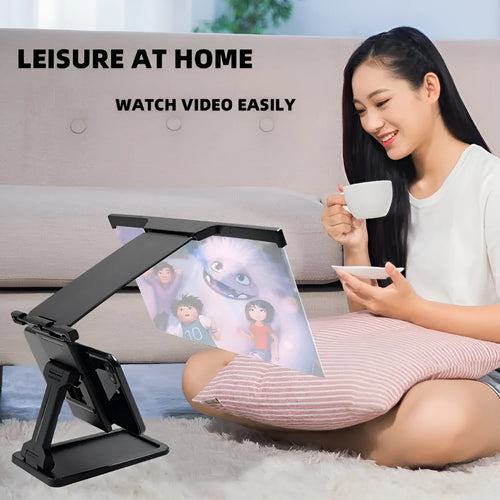 Black folding mobile phone screen amplifier with detached phone holder on a desk