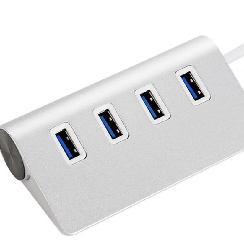Silver aluminium alloy four-port USB 3.0 hub on a desk with cables connected, 98x58x30mm