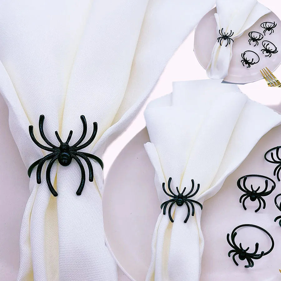Set of six black metal spider-shaped napkin rings for Halloween table decoration.