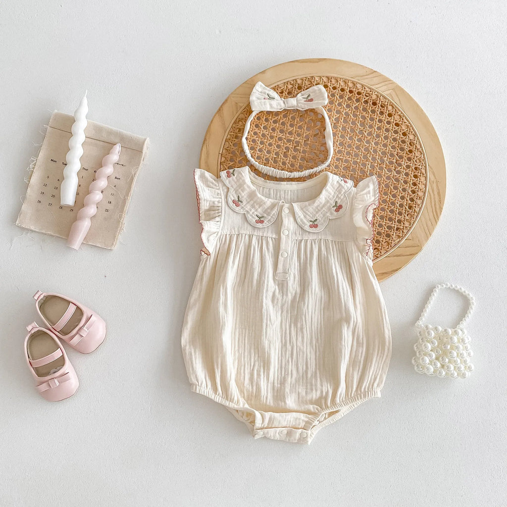 Apricot cotton double breasted sleeveless baby jumpsuit with matching hair band on white background