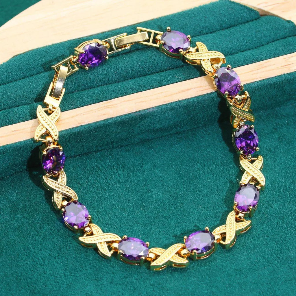 18k gold plated jewellery set showing ring, earrings, bracelet, and necklace with coloured cubic zirconia stones.