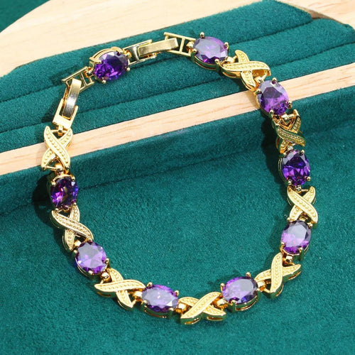 18k gold plated jewellery set showing ring, earrings, bracelet, and necklace with coloured cubic zirconia stones.