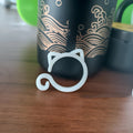 Small green plastic plant clip shaped like a cat, shown next to a plant stem.