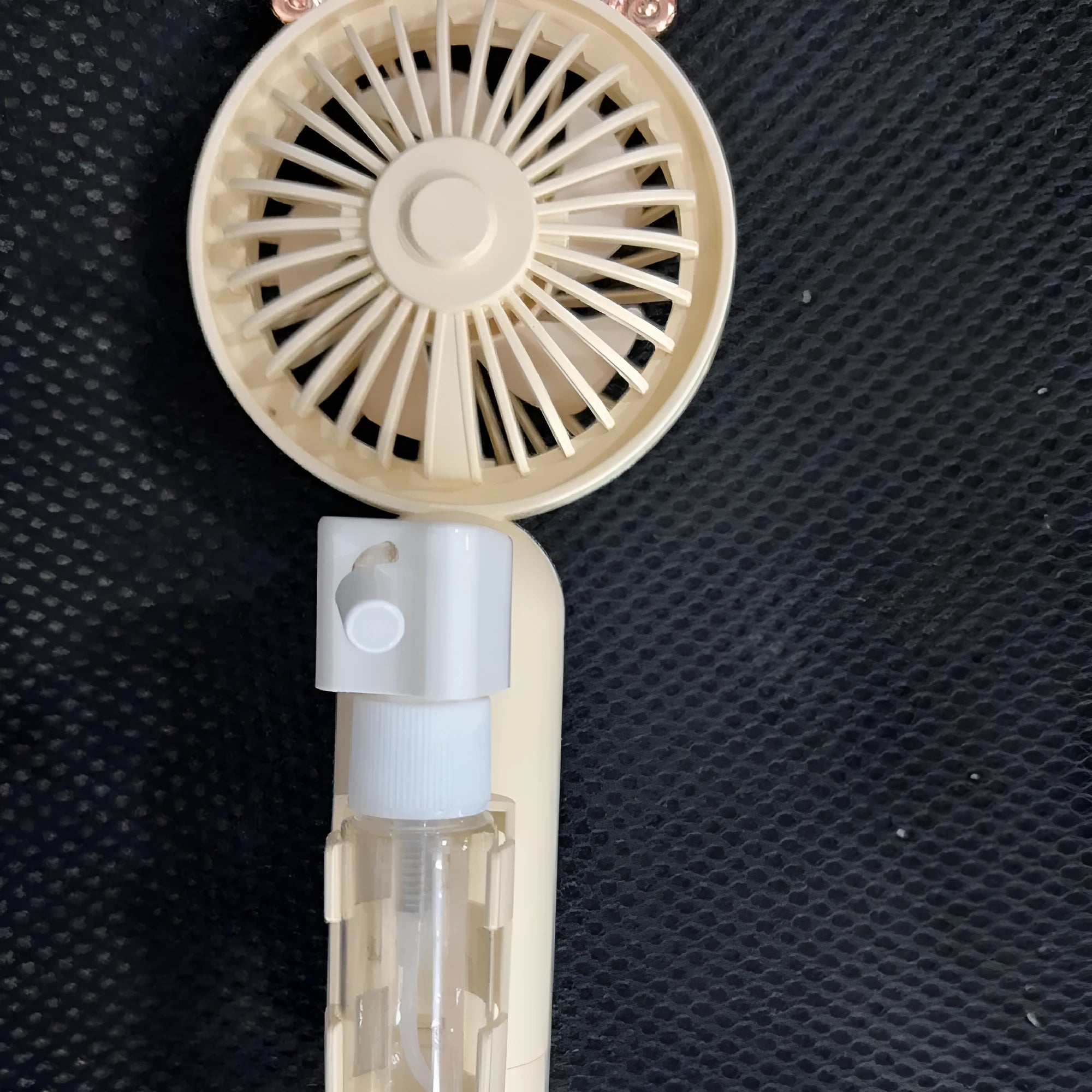 Compact plastic USB rechargeable nozzle fan in a choice of five colours on a desk.