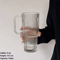 740ml round glass cup with handle, lid, and bent straw on modern table setting