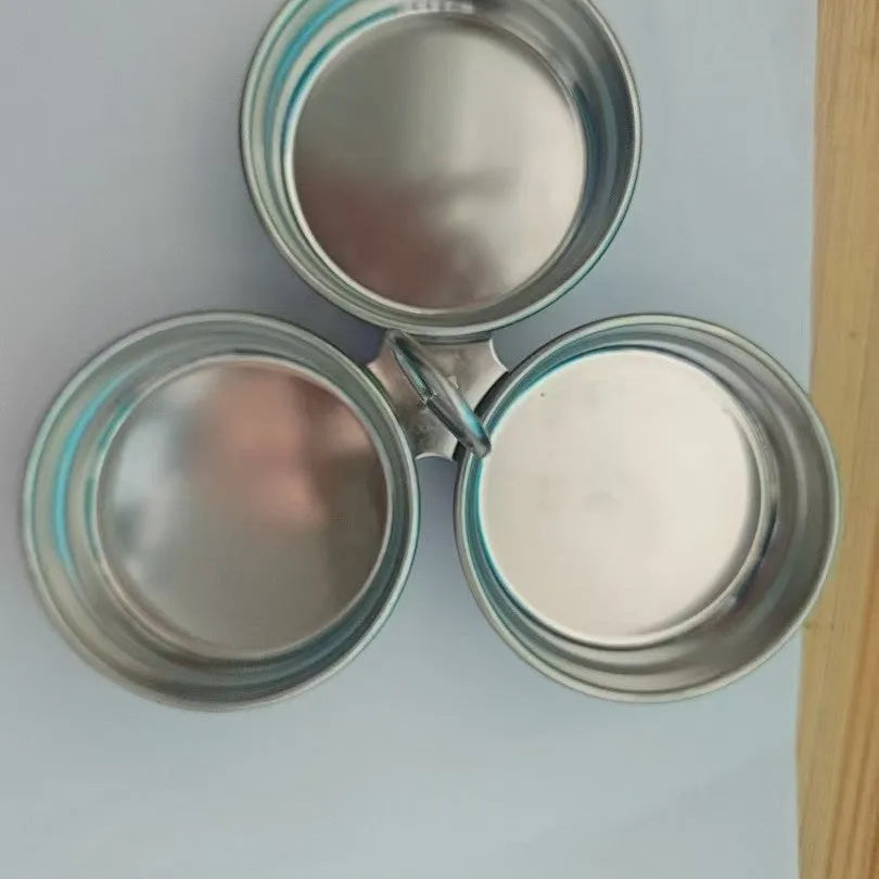 Mini stainless steel egg steamer in heart-shaped and round designs on a kitchen counter.