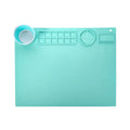 Light blue silicone painting mat measuring 50 by 40 centimetres on a wooden table.