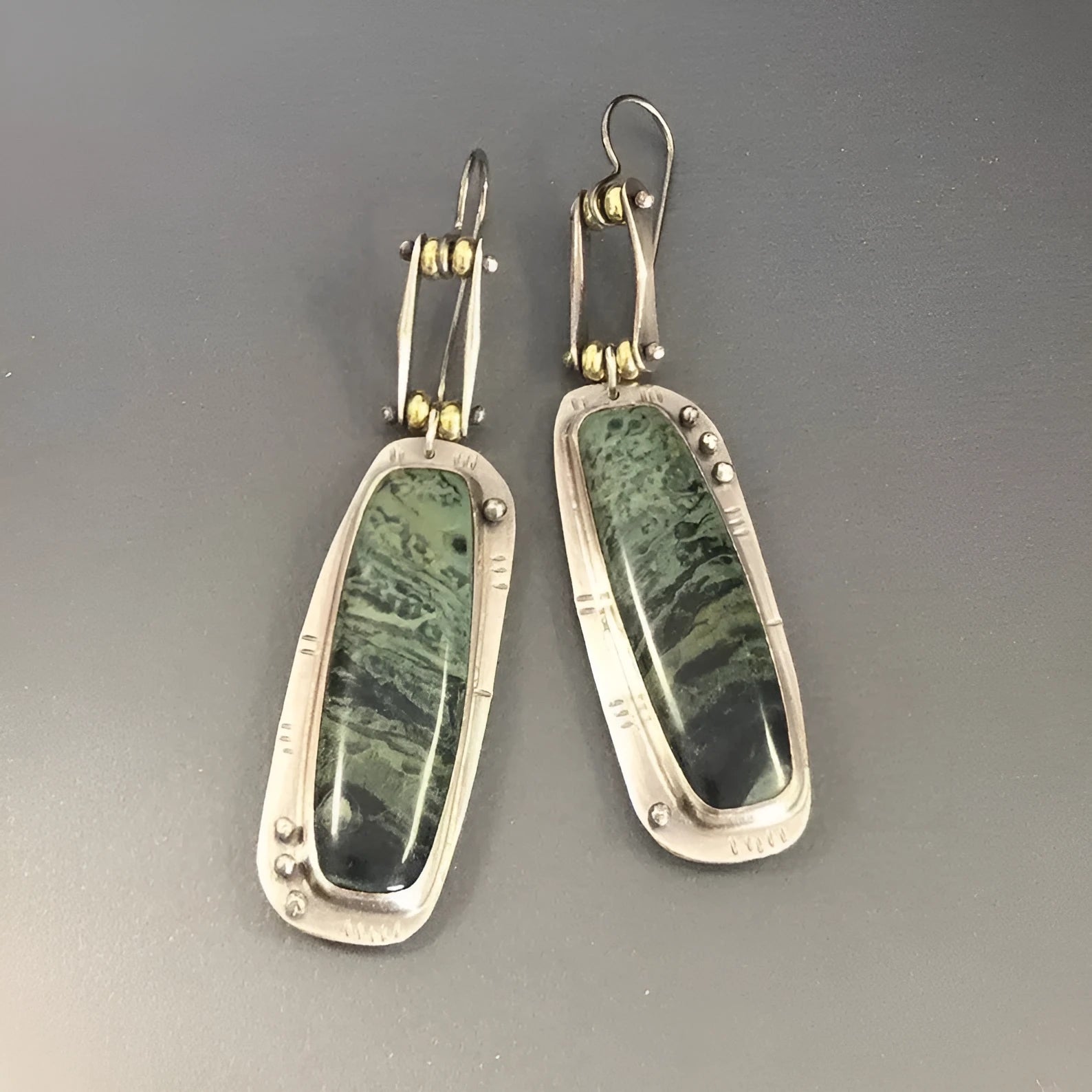 A pair of simple geometric drop earrings with a grey and white marble pattern on an alloy background.