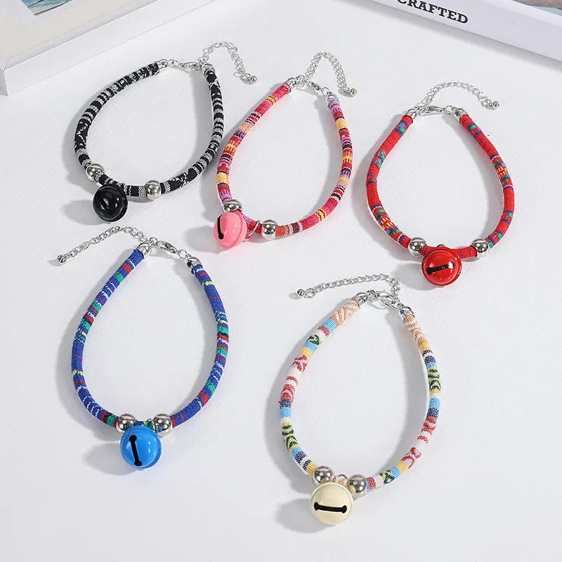 Coloured ethnic pattern adjustable pet collar with metal bell and D-ring on a nylon strap.