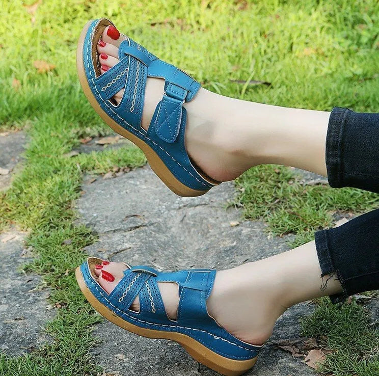 Women's red peep toe wedge sandals with a Velcro strap fastener on a white background.