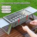 A small, foldable portable charcoal grill for outdoor cooking.