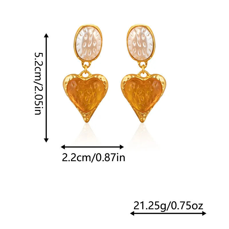 A pair of purple heart-shaped alloy stud earrings with a pleated oval texture and silver post.