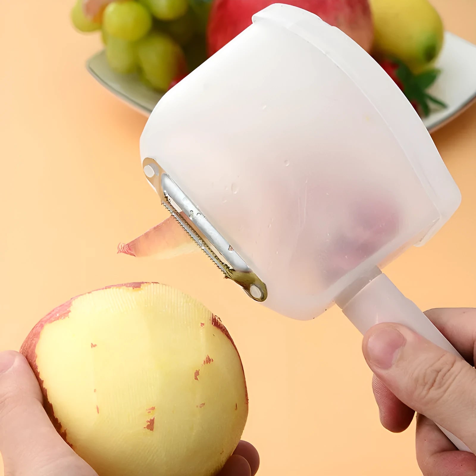 Stainless steel fruit peeler with pink plastic PP handle on light background